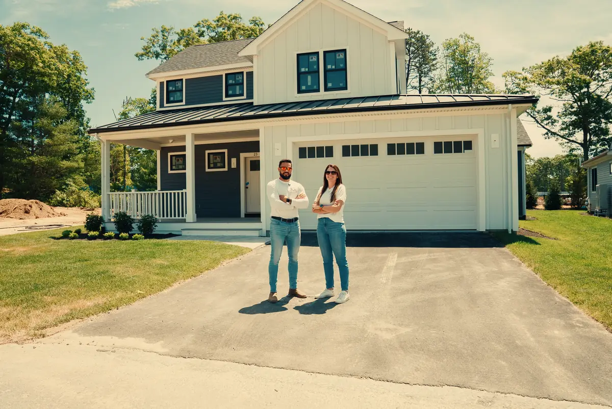 Daniel and Yasmin Fleury of Evolution Pro Builder, Randolph MA, in front of a home they built on the South Shore
