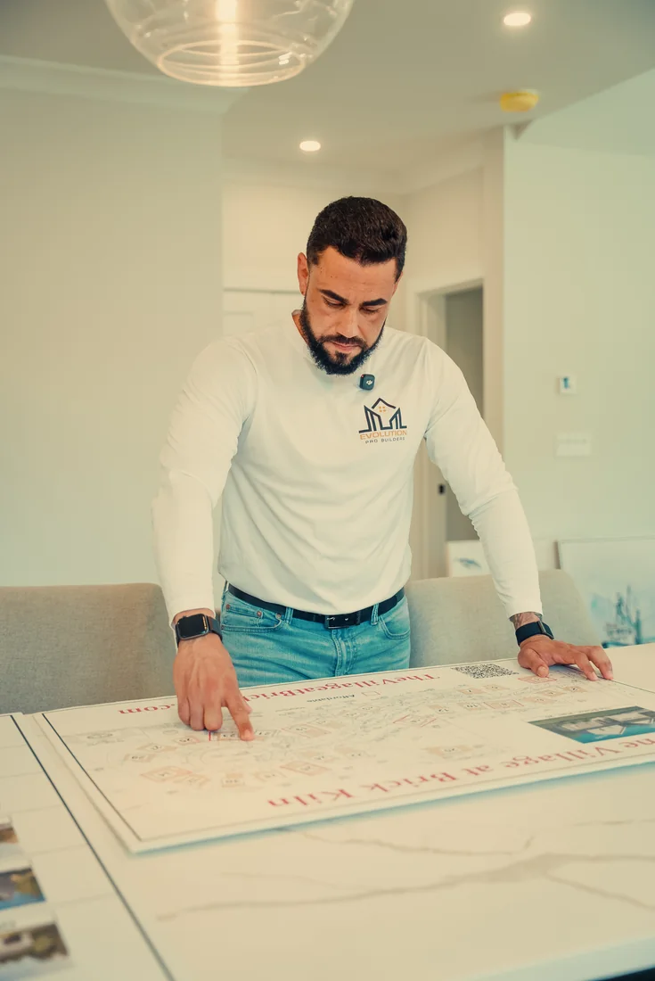 Daniel Fleury of Evolution Pro Builder, Randolph MA, over the site plan of a South Shore subdivision