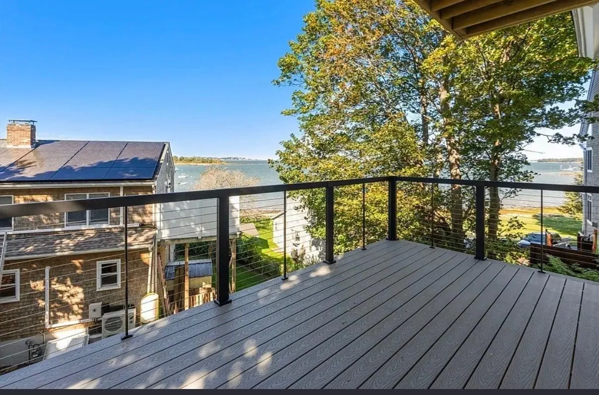 Deck builder on the South Shore: a composite deck with a cable railing, overlooking the water