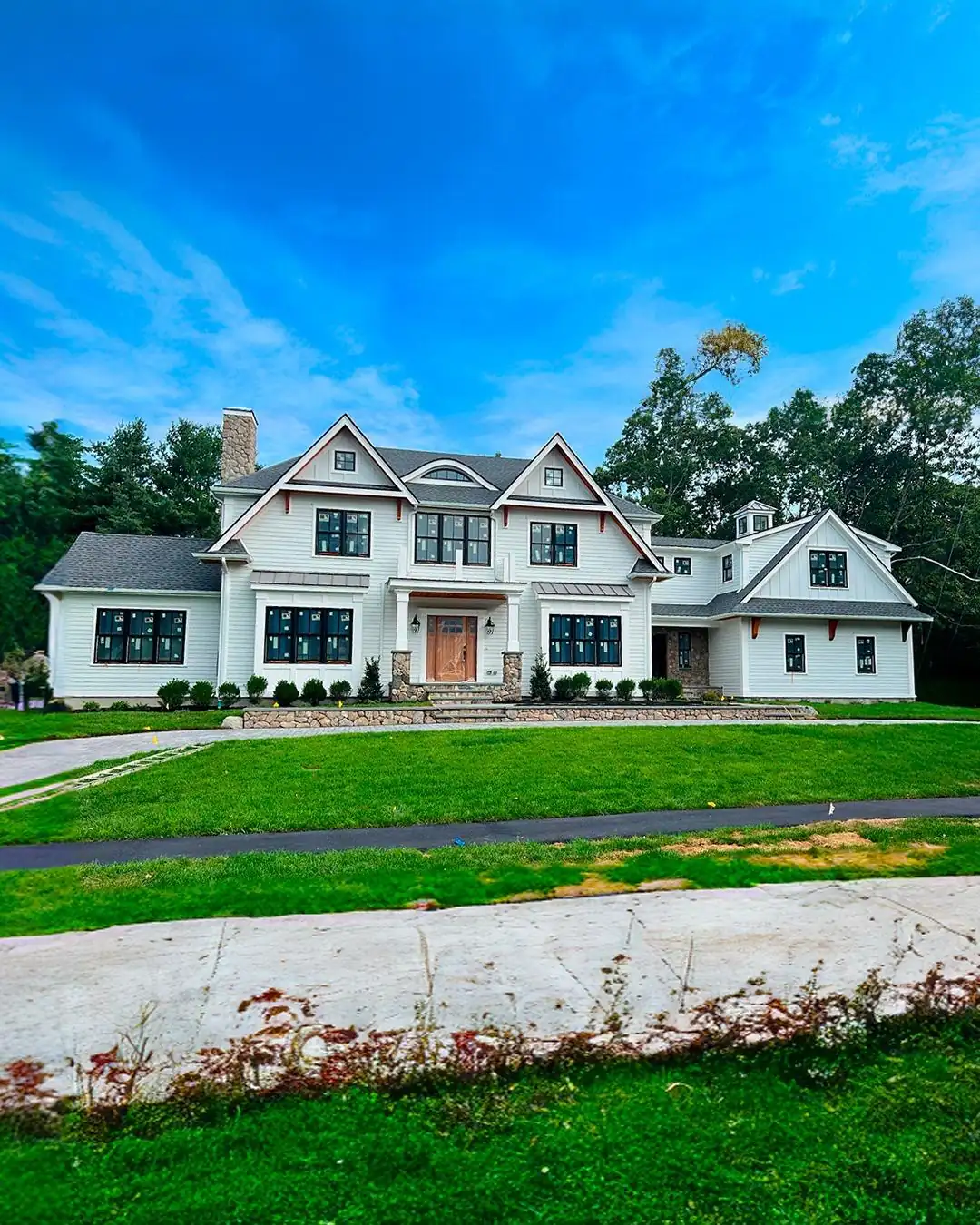 Lap siding and trim finished on a South Shore home, with the grounds landscaped